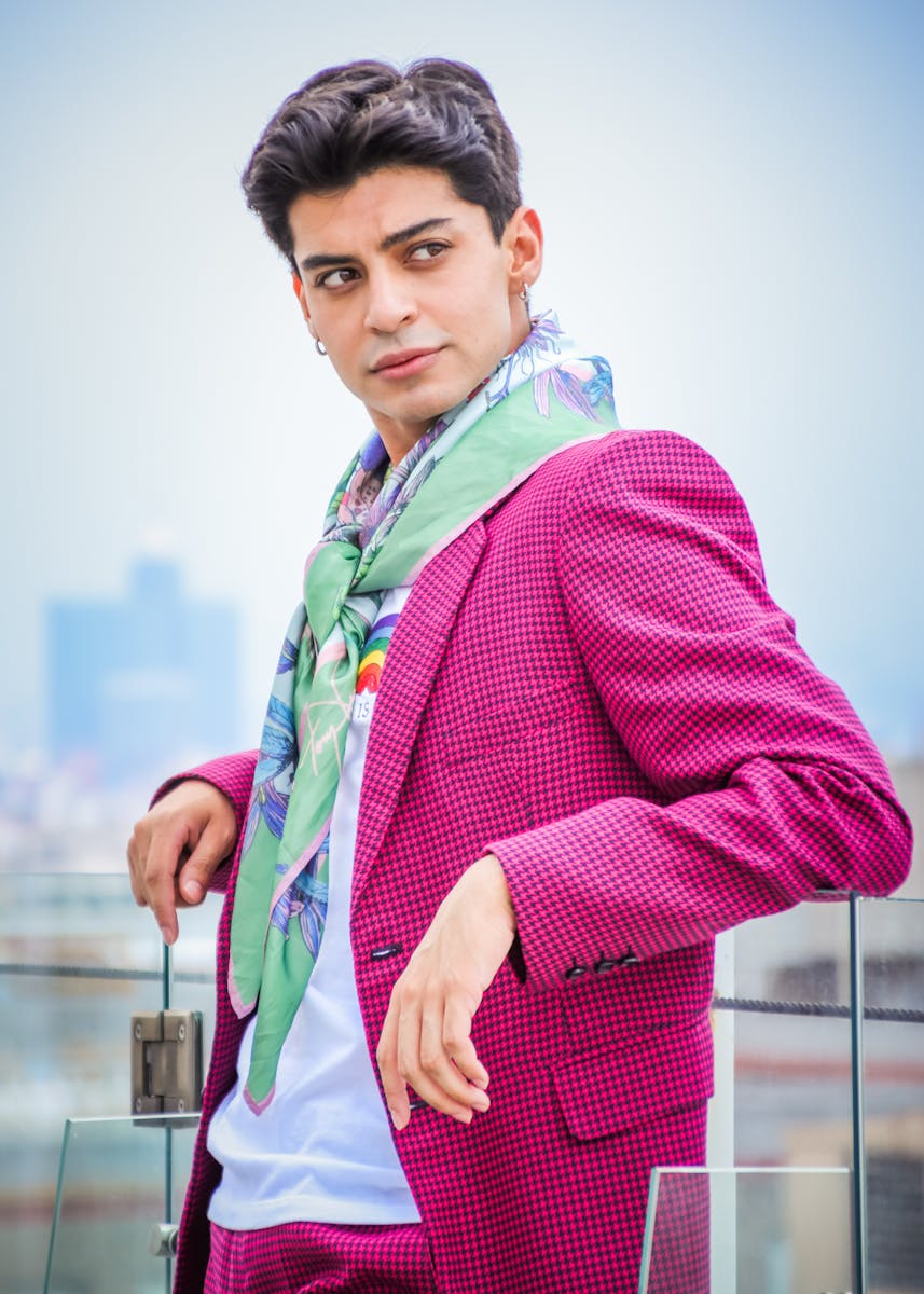 A man in a pink suit and green scarf