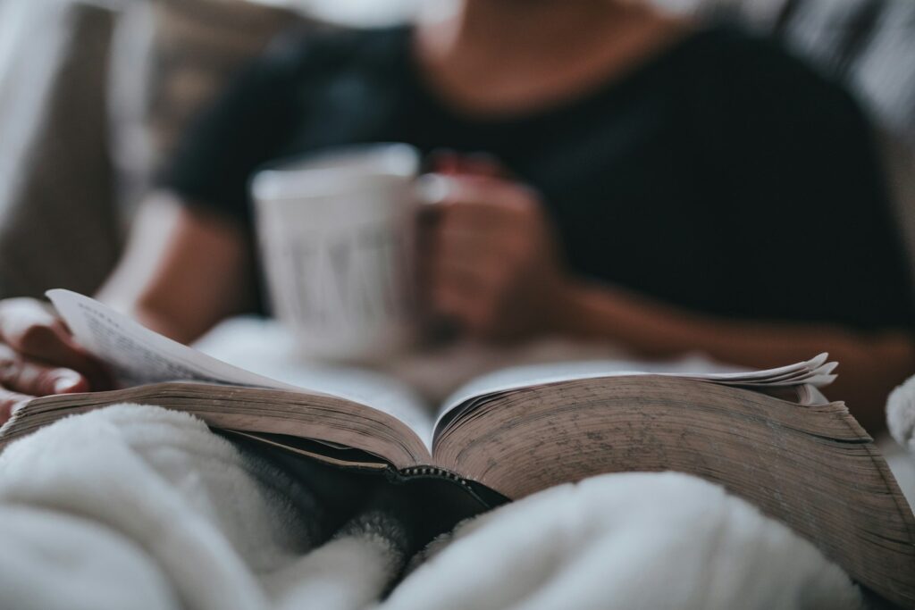 Person reading in bed with coffee