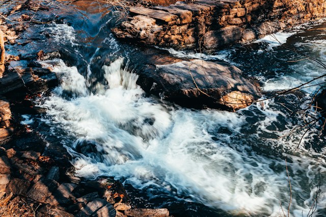 Water rushes over dark rocks